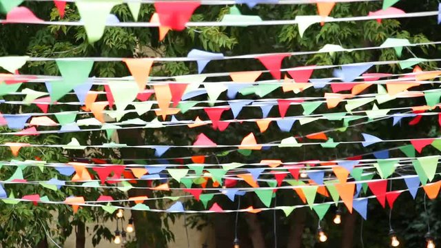 Multicolored festive small flags of a triangular shape swaying in the wind