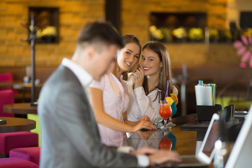 Young buseness people in a bar smiling and working