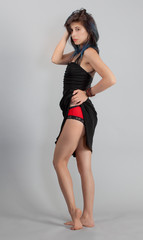 Woman Flirtatiously Pulling Up Black Dress to Reveal Red Panties