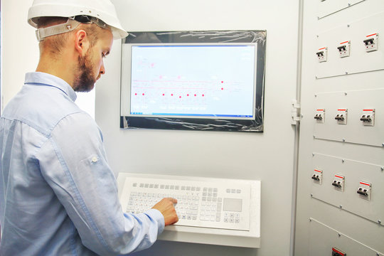 engineer controls technological equipment from remote control board. Scada system for automation equipment