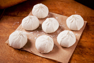 Preparing steamed dumplings on wooden table