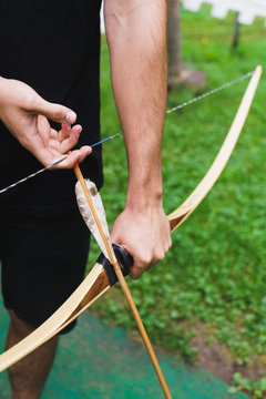 Crop man practicing archery in school