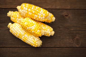 Fresh corn on cobs on rustic wooden table