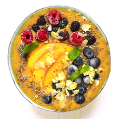 Colorful peach smoothie with wild berries and almond petals.Top view.