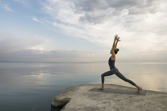 Side view of sportwoman in high lunge with arms up