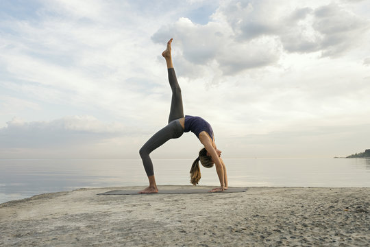 Side view of woman in upward bow pose - Powered by Adobe