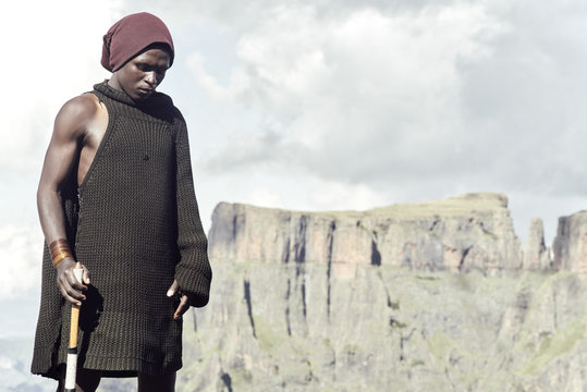 An epic portrait of a Bashoto shepherd standing in front of wild mountains.