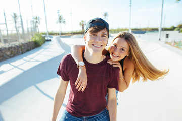 Smiling teenage couple having fun on a sunny summer day.