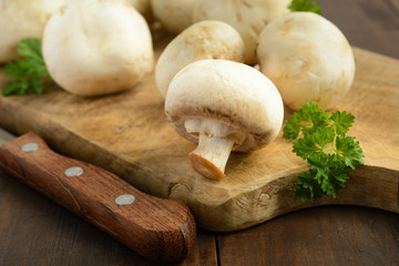 Closeup view of mushrooms and greens on wooden background