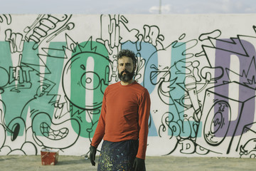 Man painting in a graffiti wall