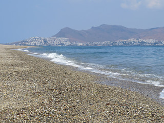 a deserted beach after a storm against the backdrop of the Turkish mountains, Kos Island, Greece