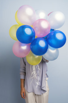 Unrecognizable girl with colorful balloons