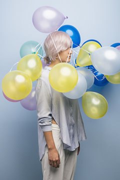 Pink-haired girl with balloons over her head