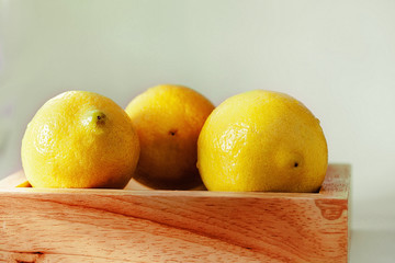 Fresh lemons in a wood basket on the White ground. Macro style