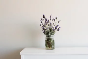 Photo sur Aluminium Lavande Lavender in glass jar on white cabinet against neutral wall background
