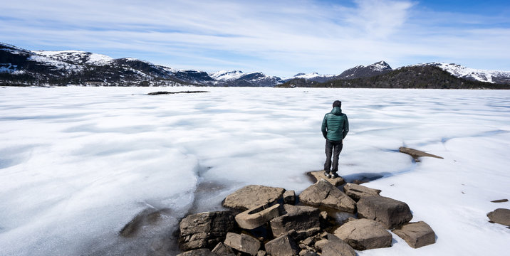 Man looking out over a frozen lake in Norway