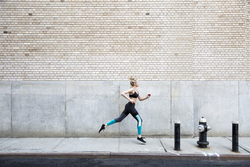 Woman running fast paced down a street