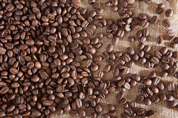 Coffee beans scattered on a jute bag. 