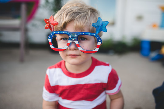 Young boy wearing patriotic glasses for fourth of july