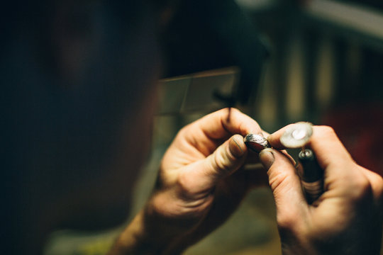 one adult male jeweler crafts a ring