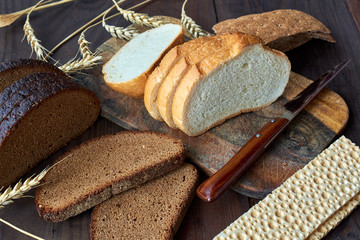 Assortment of baked bread on wooden table background