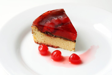 isolated on white served slice of fresh baked delicious cherry cheese cake with cherry topping