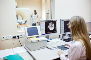 Obraz na płótnie Canvas MRI machine and screens with doctor and nurse