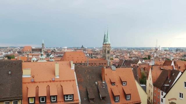 NUREMBERG, GERMANY August 14, 2017: Church and old town with cloudy sky by day timelapse, zoom out - a view on the old town nuremberg with red roofs and St. Sebald church