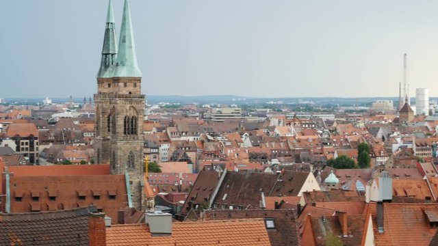 NUREMBERG, GERMANY August 14, 2017: Church and old town with cloudy sky by day timelapse, zoom out - a view on the old town nuremberg with red roofs and St. Sebald church