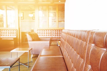 Interior design for coffee shop with brown leather sofa and orange flare effect for warm tone