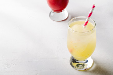 Strawberry smoothies and ice lemonade with cocktail tubes in glasses, on white background.