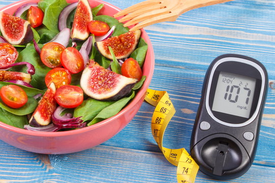 Fruit and vegetable salad and glucose meter with tape measure, concept of diabetes, slimming and healthy nutrition