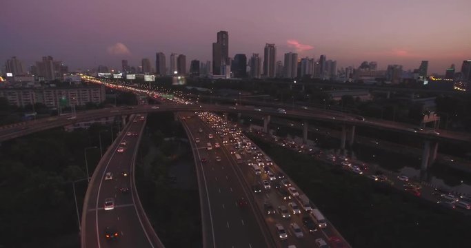 Congestion On Expressway And Bangkok City Skyine At Dusk, Thailand, Aerial Slider Shot

