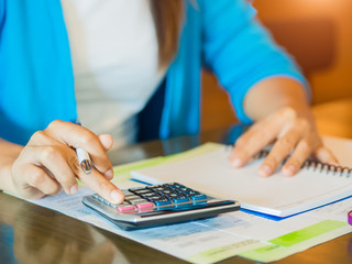 Woman working with calculator, business document and notebook.