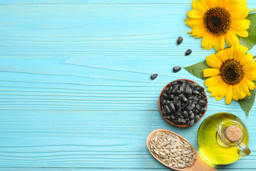 Sunflower oil, seeds and flower on blue wooden background. top view with copy space