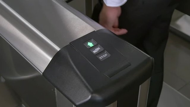 Hands of people apply electronic pass to turnstile wicket checkpoint in office. Modern equipment of access system in business center closeup. Macro video. Successful employees are not late.