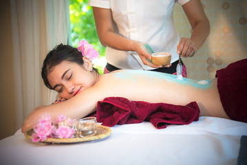 Obraz na płótnie Canvas Masseur doing massage spa with treatment sugar srcup on Asian woman body in the Thai spa lifestyle, so relax and luxury. Healthy Concept
