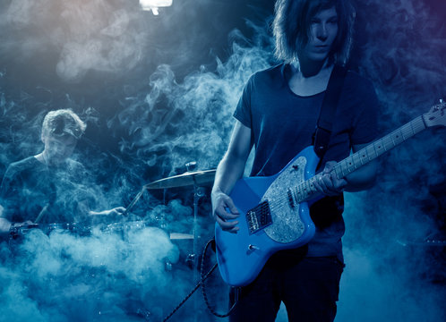 Guitarist plays solo.