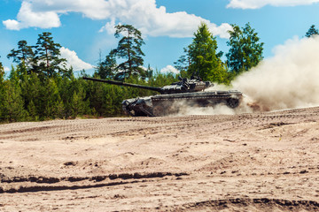 Fototapeta premium Main battle tank are going to dust on the ground for military exercises