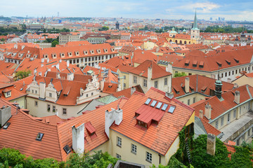 Fototapeta na wymiar The old town's ceramic tiles rooftops, Prague, Czech Republic. Red Shingles Roof with attic and skylights windows. Typical Architecture of Czech Republic, Prague.