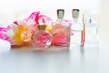 Perfume bottle with flowers on light background. Perfumery, cosmetics, fragrance collection.