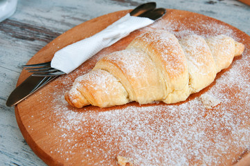 Croissant on the wooden board. Fresh and tasty croissants