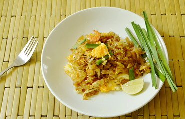 Pad Thai stir fried rice noodles with dry shrimp and yellow tofu on plate
