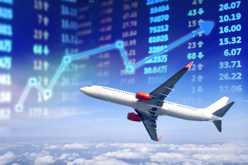 Naklejka na ściany i meble Travel business stock market chart, Stock market data with plane above the cloud and stock market board display