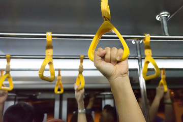 woman hand holding onto a handle of bus (blur background)