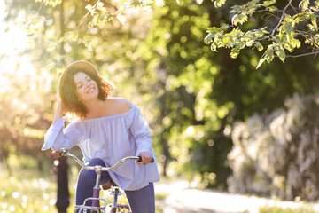 Fototapeta na wymiar Beautiful young woman with bicycle, outdoors