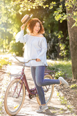 Fototapeta na wymiar Beautiful young woman with bicycle, outdoors