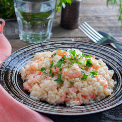 Serving of risotto with white rice and shrimps, square