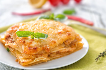 Plate with tasty lasagna on table