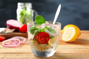 Vegetable salad with quinoa served in glass on kitchen table